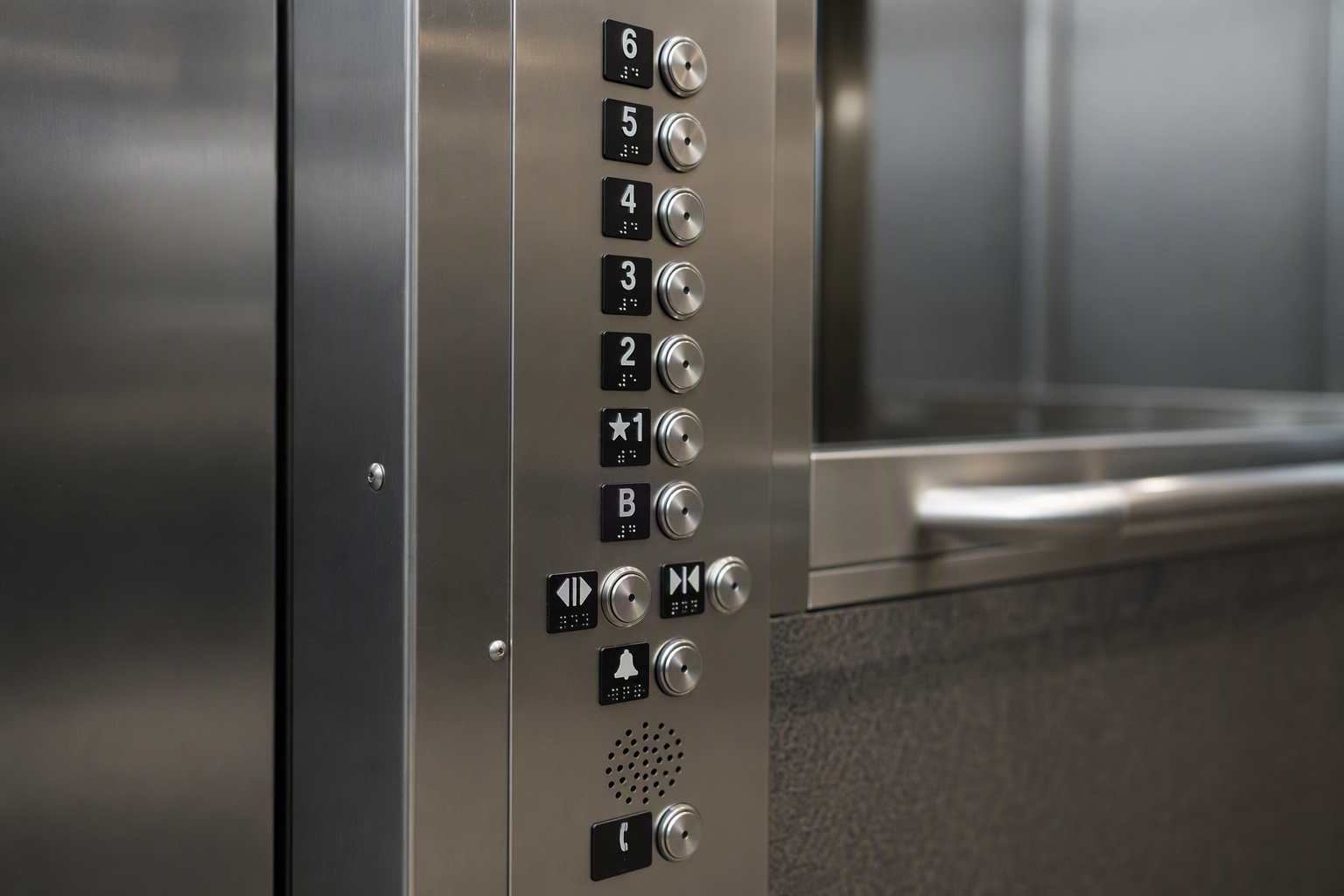 ADA-compliant elevator control panel with Braille designations and raised characters inside a university campus elevator cab in Arizona