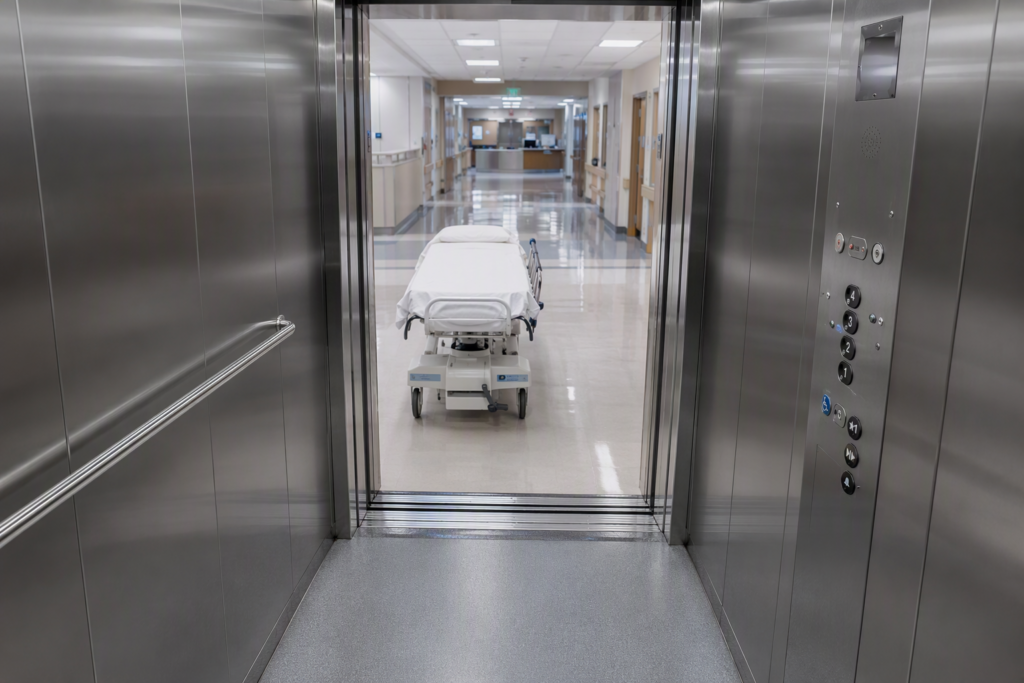 Hospital elevator cab with open doors and gurney in Arizona healthcare facility, illustrating elevator maintenance and inspection requirements for hospitals