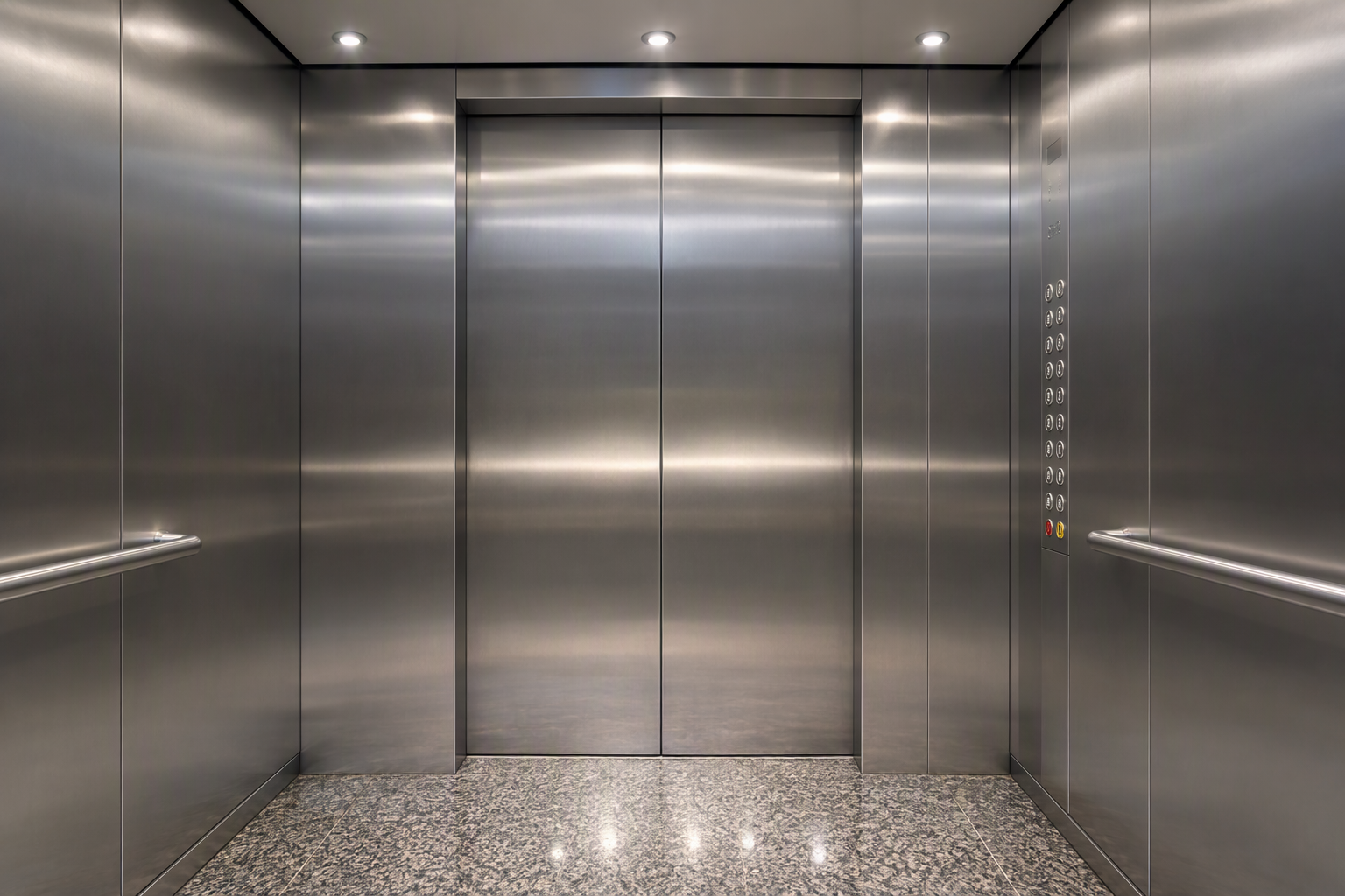 Interior of a modernized commercial elevator cab in Phoenix AZ showing stainless steel panels, LED lighting, and ADA-compliant Braille button panel